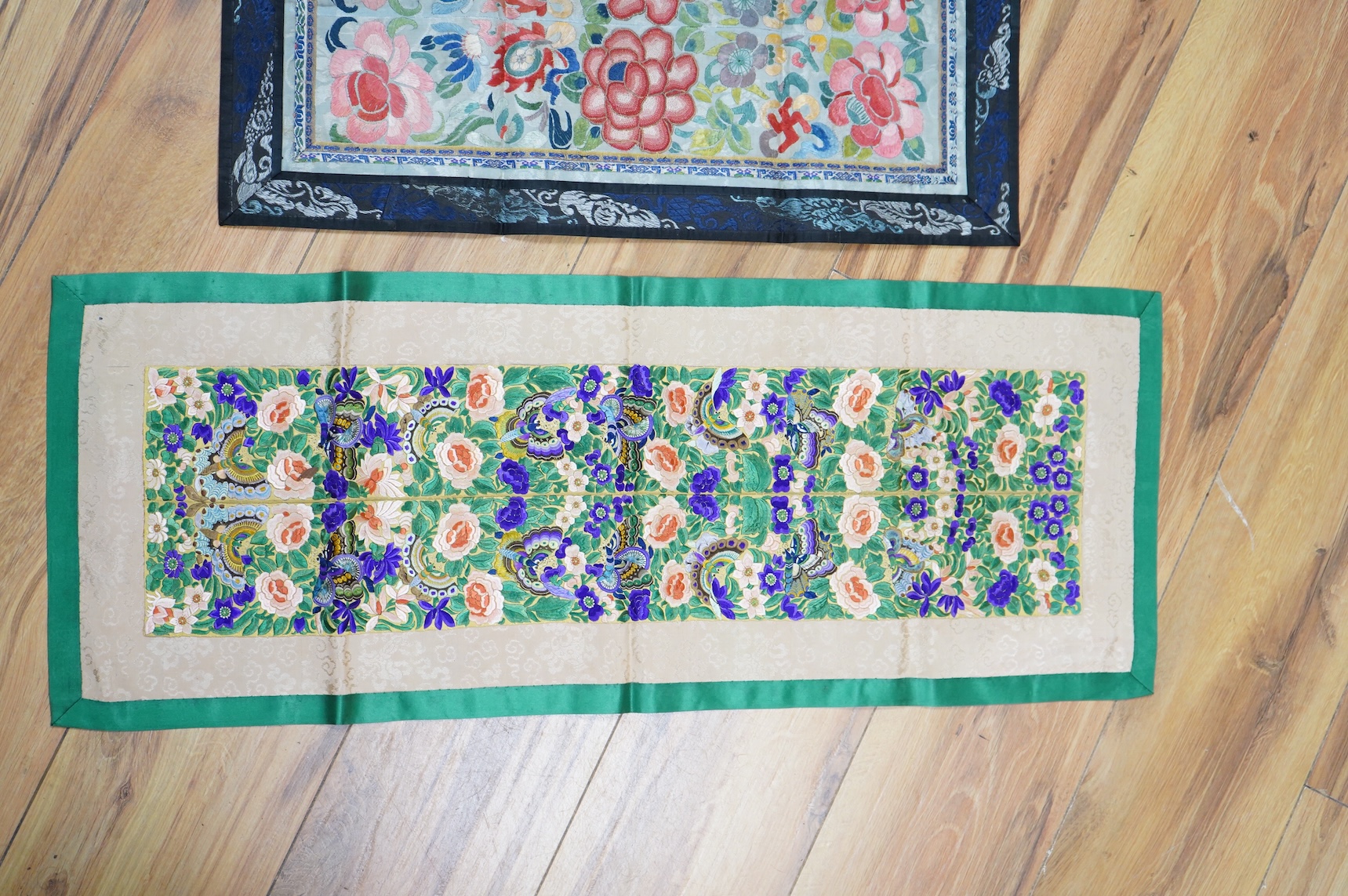 Two pairs of Chinese late 19th / early 20th century polychrome silk embroidered sleeve bands, now converted into two decorative table runners, one embroidered with large flowers using Peking knot, the other heavily embro